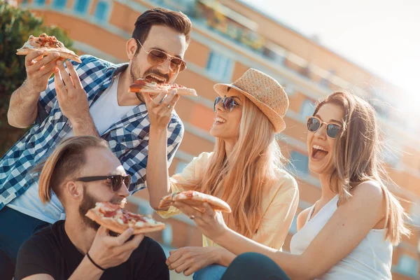 Grupp av vänner med deras bitar pizza — Stockfoto