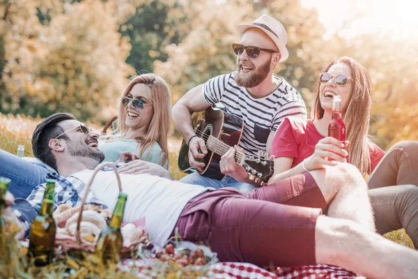 Счастливые юные друзья устраивают пикник в парке — стоковое фото