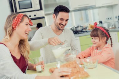 Mutlu aile kahvaltısını evde yapıyor.
