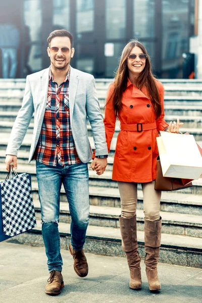 Pareja joven feliz con bolsas de compras —  Fotos de Stock