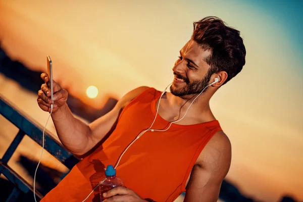 Jovem ouvindo música em um telefone inteligente — Fotografia de Stock