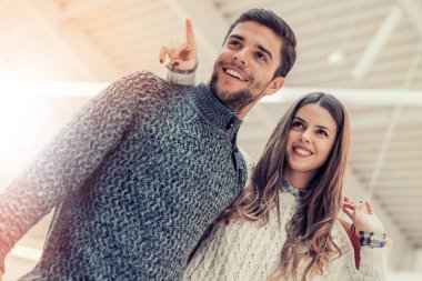 Güzel, genç bir çift alışveriş torbaları taşıyor.