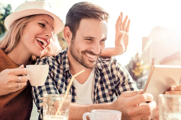 Jeune couple dans un café, riant — Photo