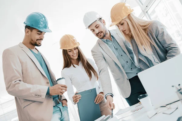 Arquiteto olhando sobre os planos de construção com trabalhadores da construção — Fotografia de Stock