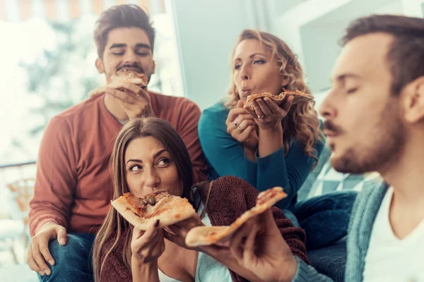 Vrienden die thuis pizza eten — Stockfoto