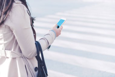 Akıllı telefon kullanan genç bir kadın.