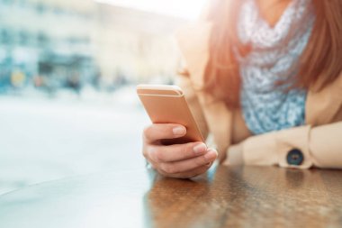 Akıllı telefon kullanan genç bir kadın.