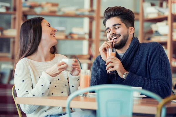 Unga par sitter i café och skrattar — Stockfoto