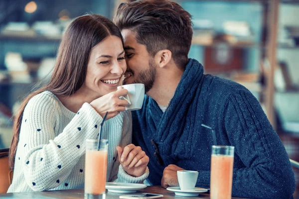 Young couple sitting in cafe and laughing — Stock Photo, Image