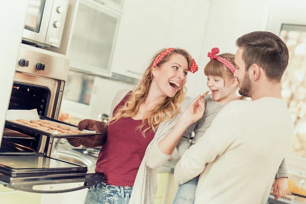 Família feliz fazendo biscoitos em casa — Fotografia de Stock