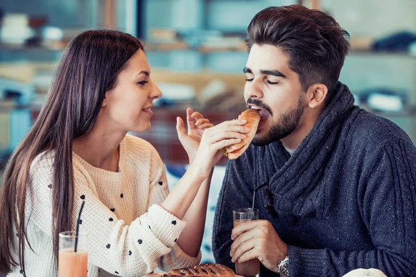 Счастливая молодая пара завтракает в кафе — стоковое фото