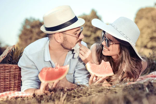 Pareja joven comiendo sandía en una cita de picnic — Foto de Stock