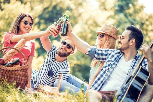 Felices jóvenes amigos haciendo picnic en el parque —  Fotos de Stock