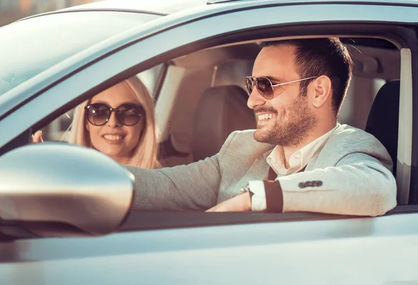 Beau jeune couple heureux conduisant la voiture — Photo