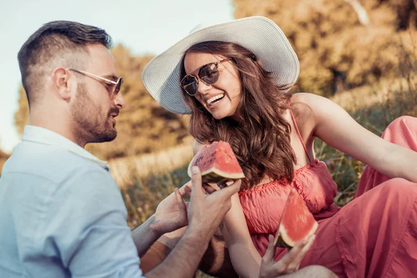 Ungt par spiser vandmelon på en picnic dato - Stock-foto