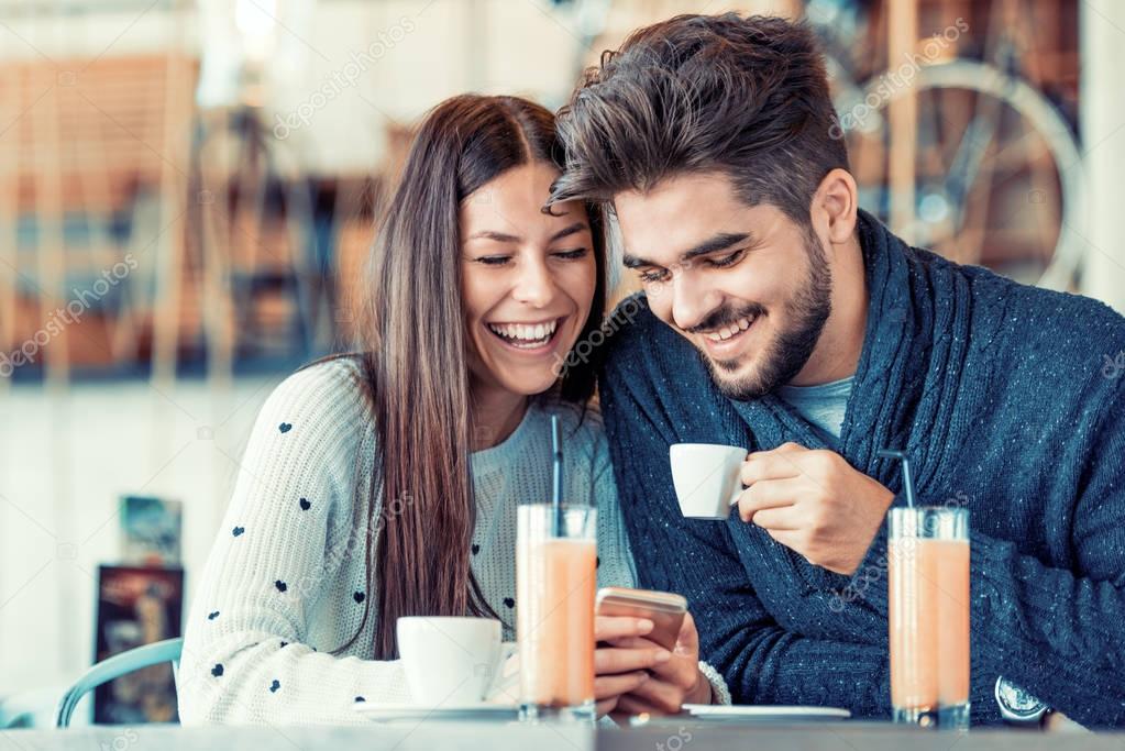 Happy young couple having fun in cafe