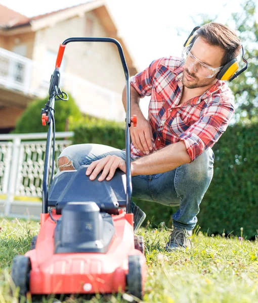 Hombre cortando hierba en su patio — Foto de Stock