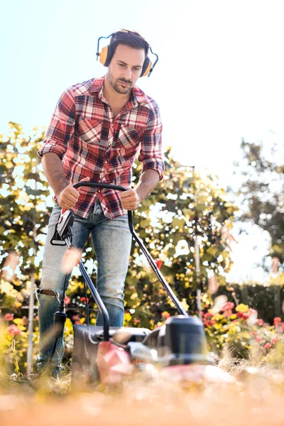 Hombre cortando hierba en su patio — Foto de Stock