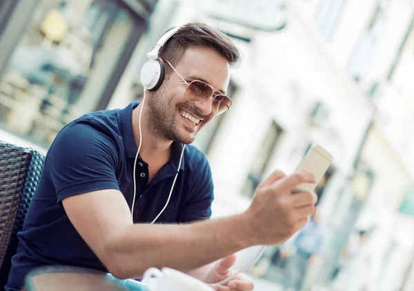 Hombre escuchando música en un teléfono inteligente — Foto de Stock