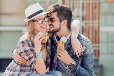 Mutlu genç çift sandviç yeme