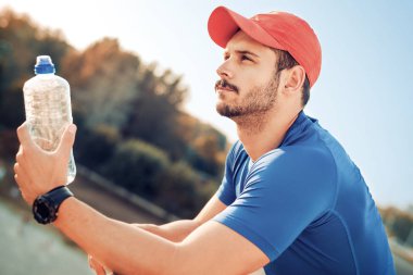 Genç adam bir şişe su içme portresi 