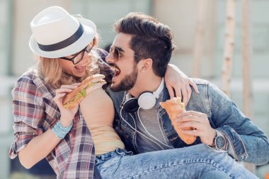 Mutlu genç çift sandviç yeme