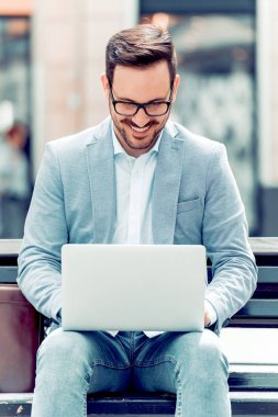 dizüstü bilgisayar kullanan yakışıklı genç