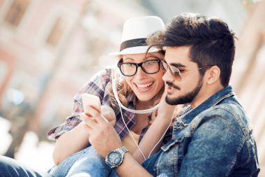 Mutlu çift kulaklıklarla müzik paylaşımı