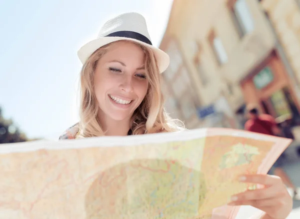 Gelukkig jonge vrouw met behulp van een plattegrond van de stad — Stockfoto