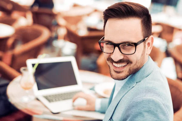 Schöner junger Mann mit Laptop — Stockfoto