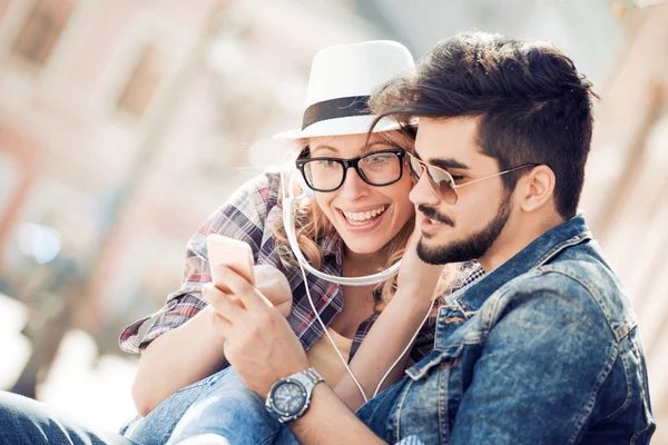 Glückliches Paar mit Kopfhörern, die Musik teilen — Stockfoto