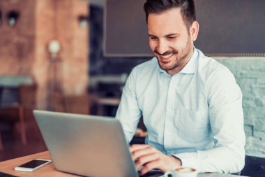 dizüstü bilgisayar kullanan yakışıklı genç