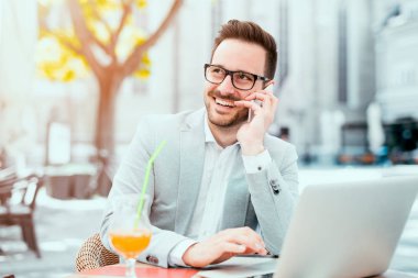 Kafede oturan ve diz üstü kullanarak genç adam