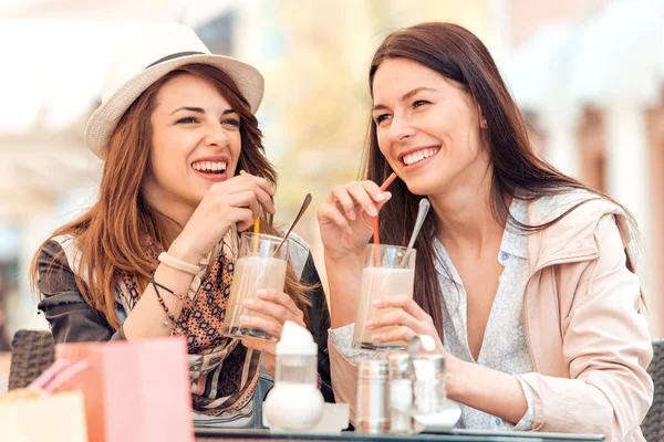 Dos hermosas chicas jóvenes sentadas en un café — Foto de Stock