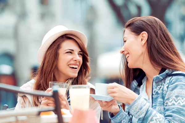 Twee mooie jonge meisjes zitten in een cafe — Stockfoto