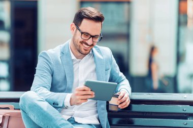 Gülümseyen yakışıklı adam dijital tablet kullanma