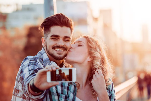 Gelukkige jonge paar in de stad nemen selfie — Stockfoto