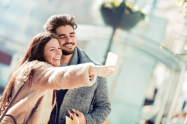 Feliz jovem casal na cidade tomando selfie — Fotografia de Stock