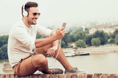 Genç adam müzikten hoşlanıyor.