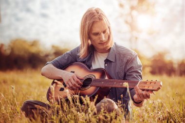Gitar çalan genç adam