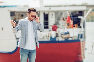 Genç adam akıllı telefon kullanıyor.