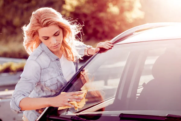 Jonge vrouw haar auto schoonmaken — Stockfoto