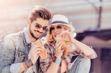 Mutlu genç çift sandviç paylaşımı