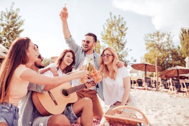 Bir grup insan sahilde eğleniyor.