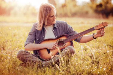 Gitar çalan genç adam