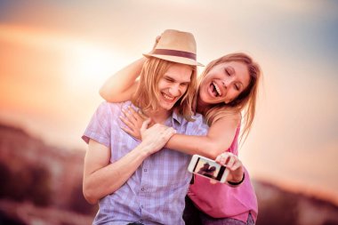 Gülümseyen çift selfie çekiyor. 