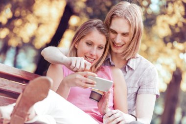 Gülümseyen çift selfie çekiyor. 