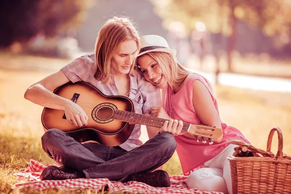 Man gitaarspelen meisje op een picknick — Stockfoto