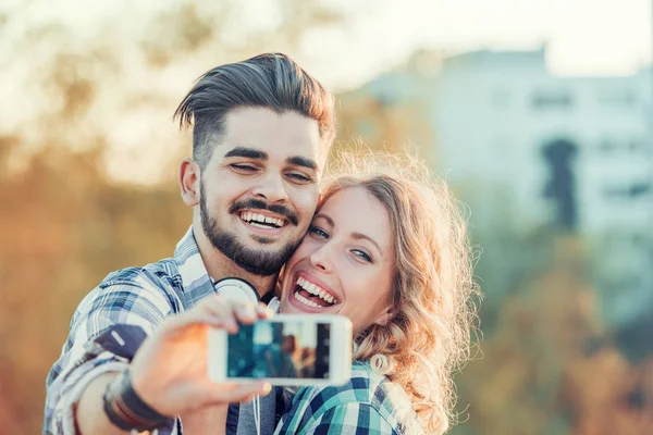 Uśmiechnięta para robi selfie — Zdjęcie stockowe