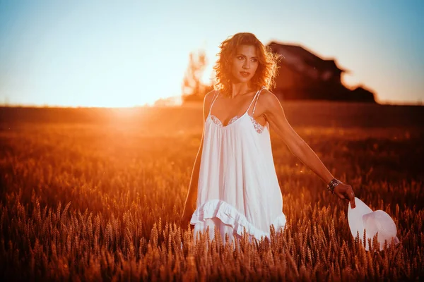 Joven mujer disfrutar de sol en campo de trigo — Foto de Stock